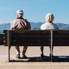 Old couple sitting on a bench.