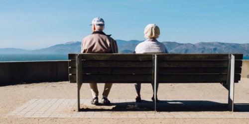 Old couple sitting on a bench.