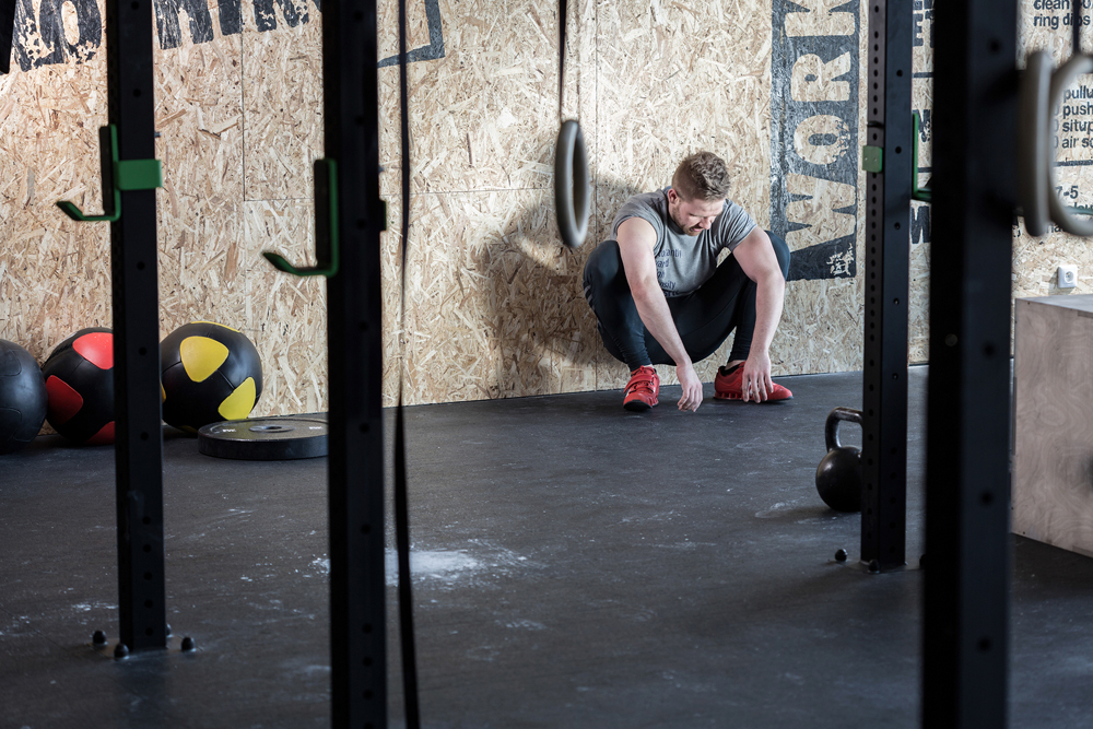 Drained man after workout in cross fit center.