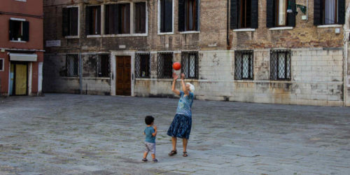 woman playing with child using basketball