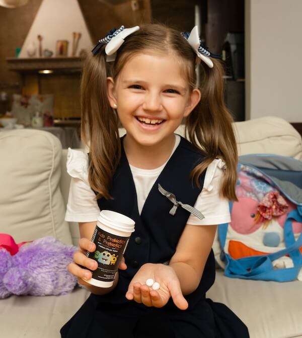 little girl holding bottle of intelligent labs children's probiotics and prebiotics