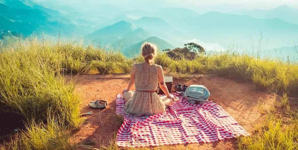 Picture of a woman enjoying a picnic at the mountains