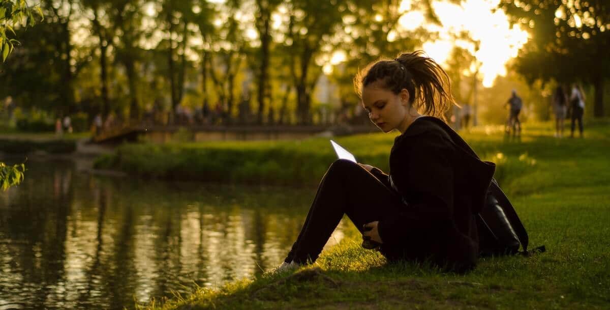 girl studying by the lake 