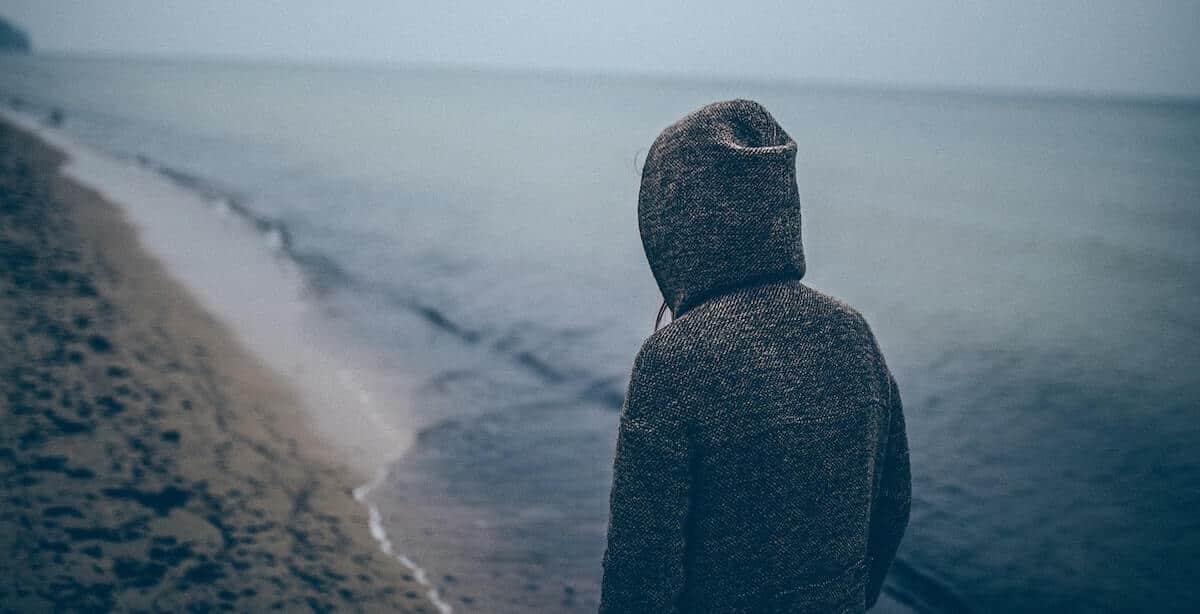 person looking out gloomily over the water