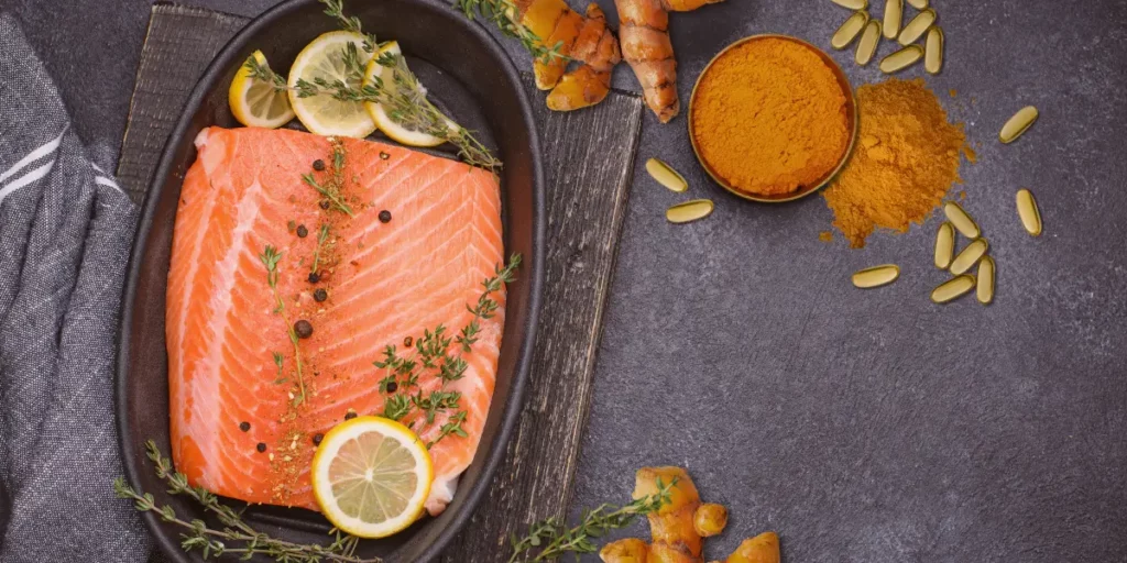 image of turmeric powder, salmon and omega-3 softgels
