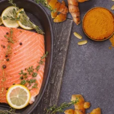 image of turmeric powder, salmon and omega-3 softgels