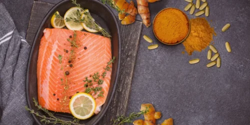 image of turmeric powder, salmon and omega-3 softgels